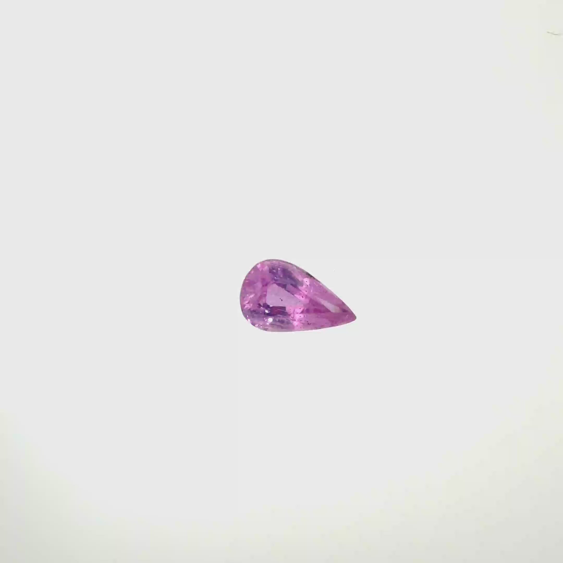 A pear-cut pink gemstone with faceted cuts, centered on a solid white background, spinning 360 degrees.