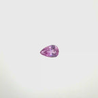 A pear-cut pink gemstone with faceted cuts, centered on a solid white background, spinning 360 degrees.