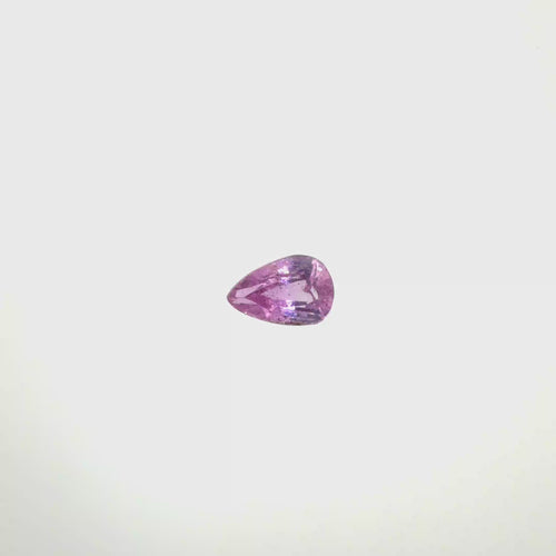 A pear-cut pink gemstone with faceted cuts, centered on a solid white background, spinning 360 degrees.